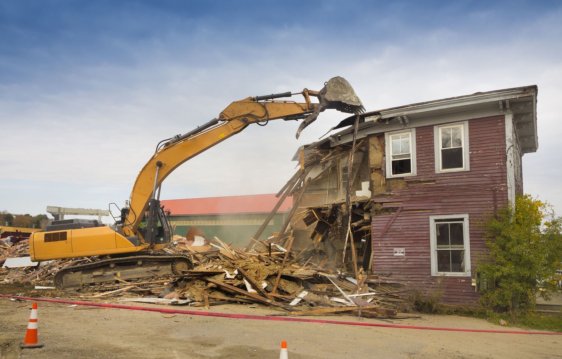 An old house is being demolished by a bulldozer.