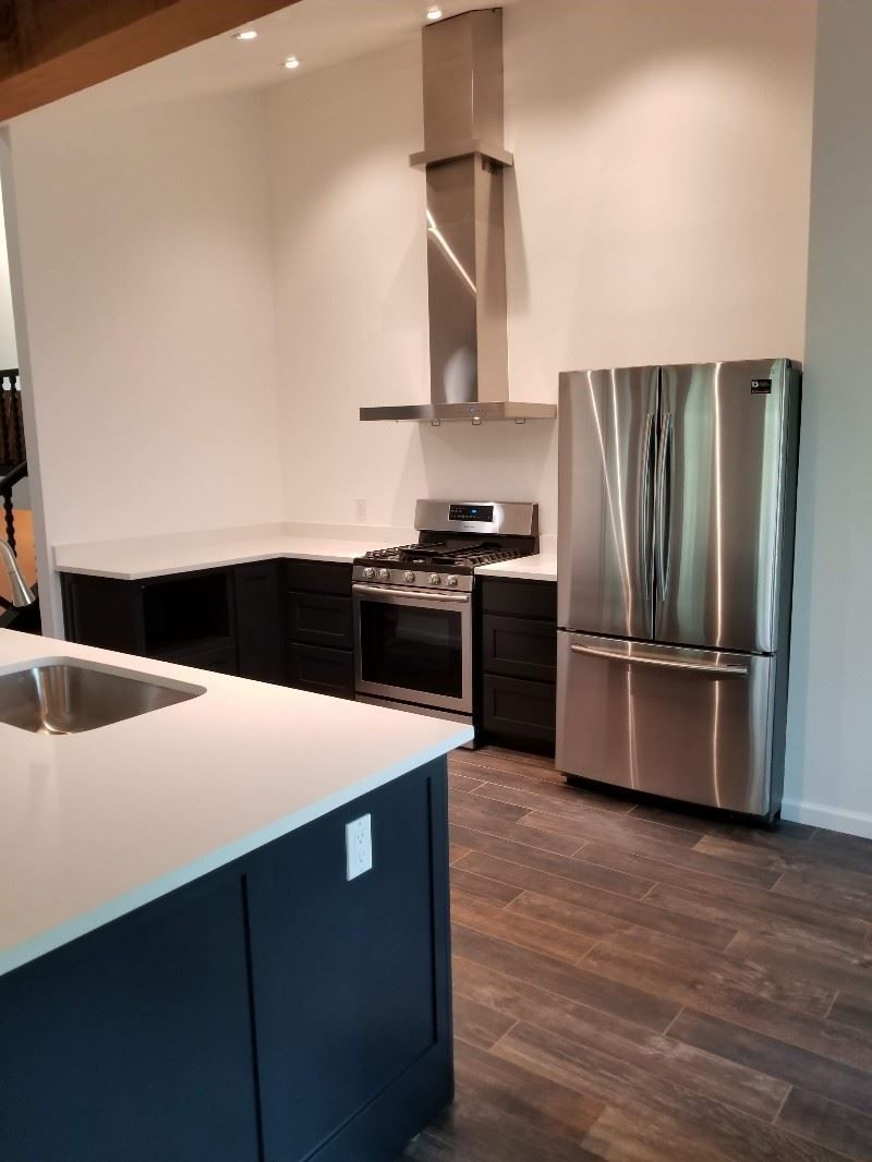 A kitchen with stainless steel appliances , a sink , stove and refrigerator.