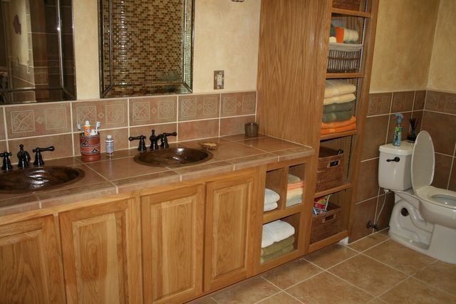 A bathroom with two sinks and a toilet