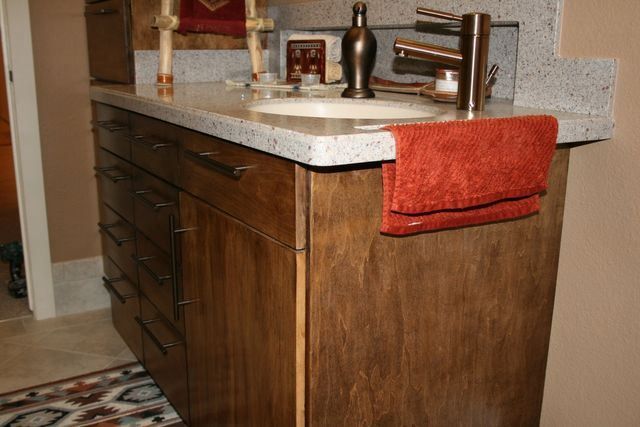 A bathroom vanity with a sink and a towel hanging on it.