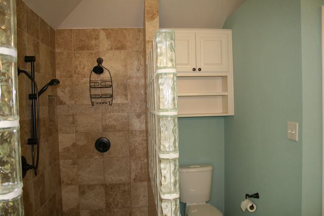 A bathroom with a toilet and a walk in shower.