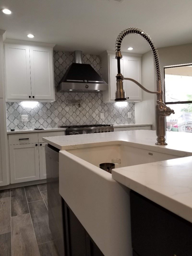 A kitchen with two sinks , a stove , and a faucet.