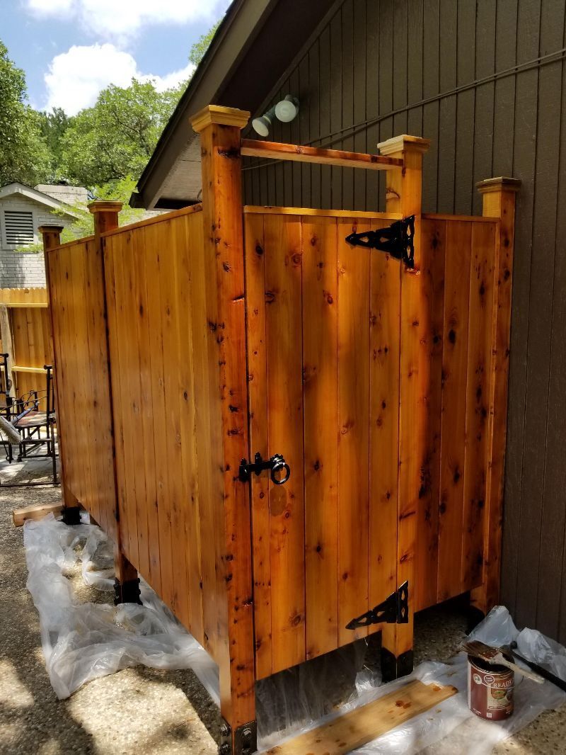 A wooden shower stall is being built in front of a house.