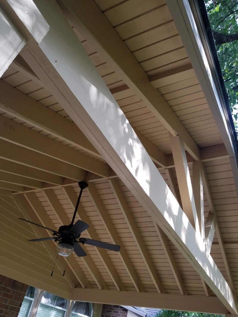 A wooden ceiling with a ceiling fan hanging from it