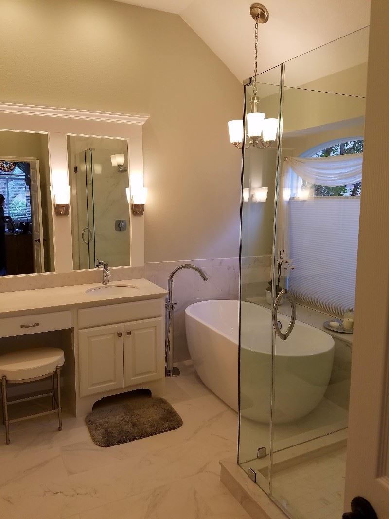 A bathroom with a tub , sink , mirror and walk in shower.