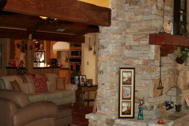 A living room with a stone fireplace and a couch.