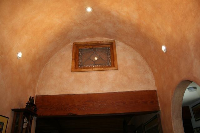 A room with arched ceiling and a picture on the wall