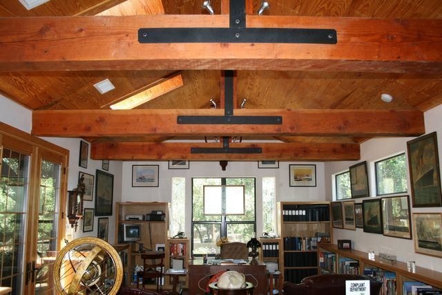 A living room with wooden beams and lots of windows
