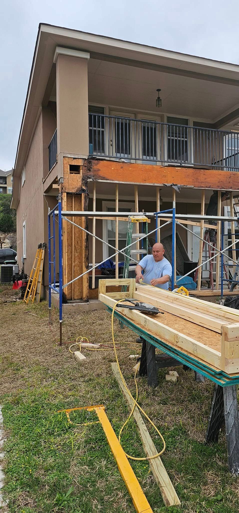 A man is standing in front of a house under construction.