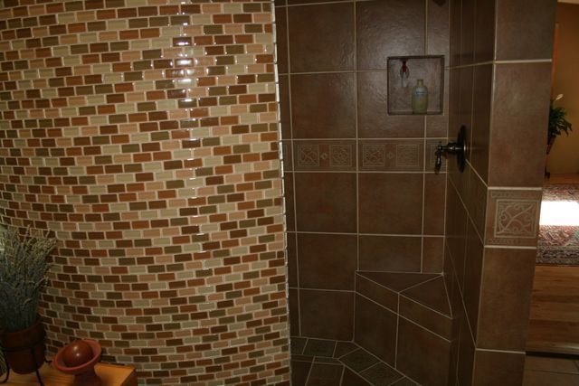 A bathroom with brown tiles and a walk in shower