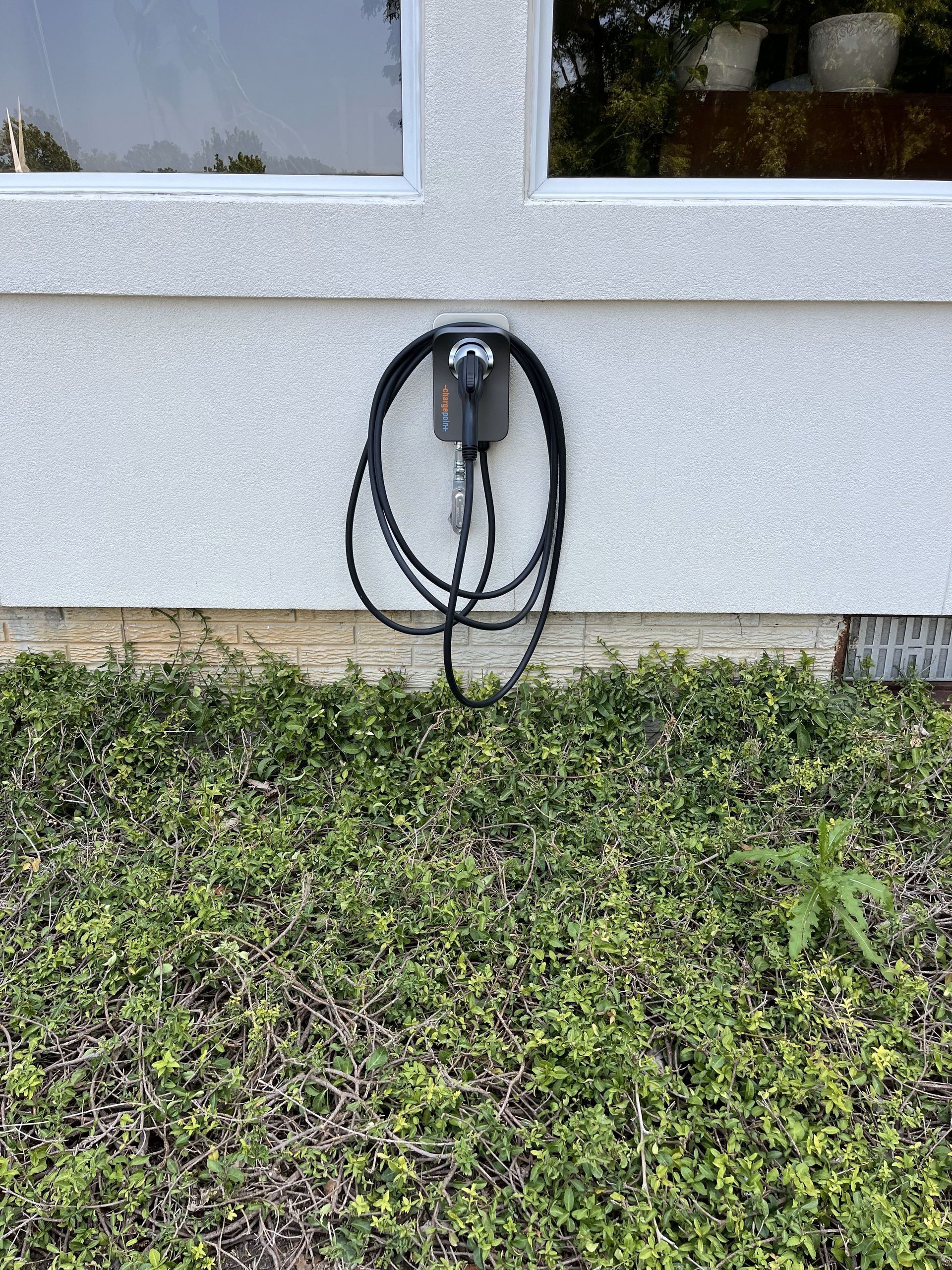 A hose is hanging from a wall next to a window.