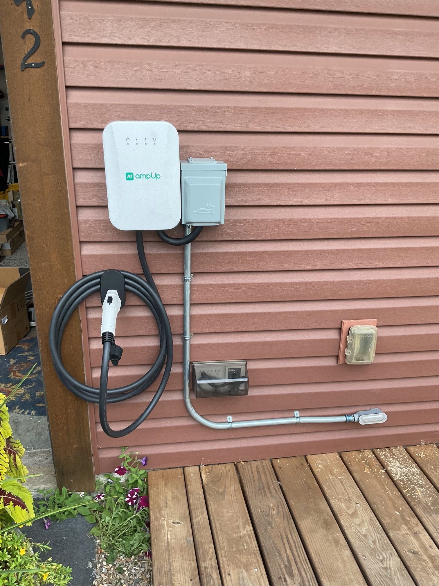 A charger is attached to the side of a house.
