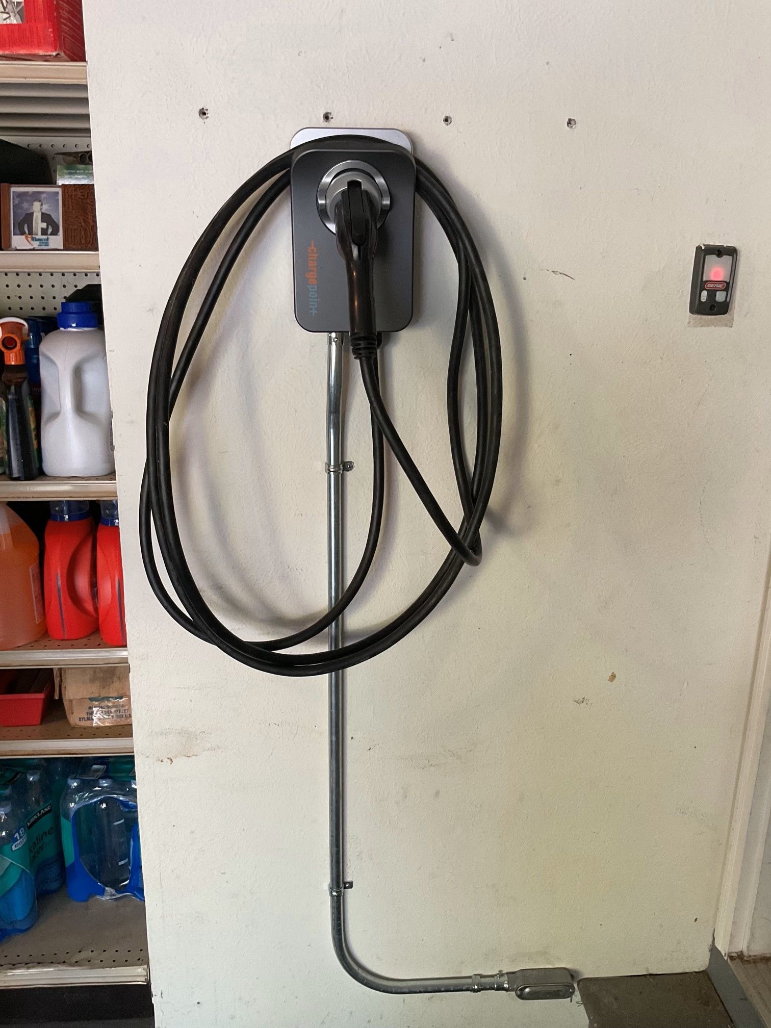 A black cord is attached to a box on a wall