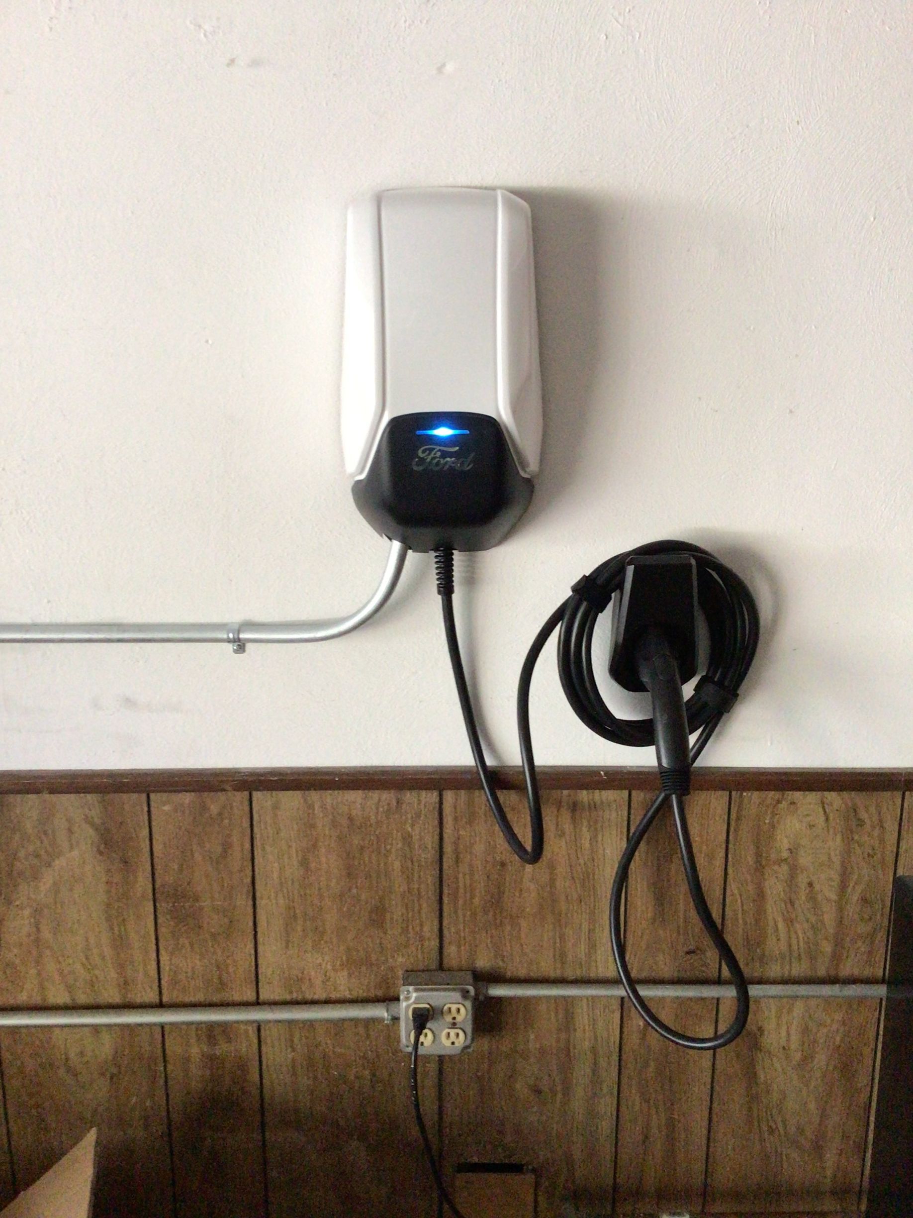 An electric car charger is attached to a wall