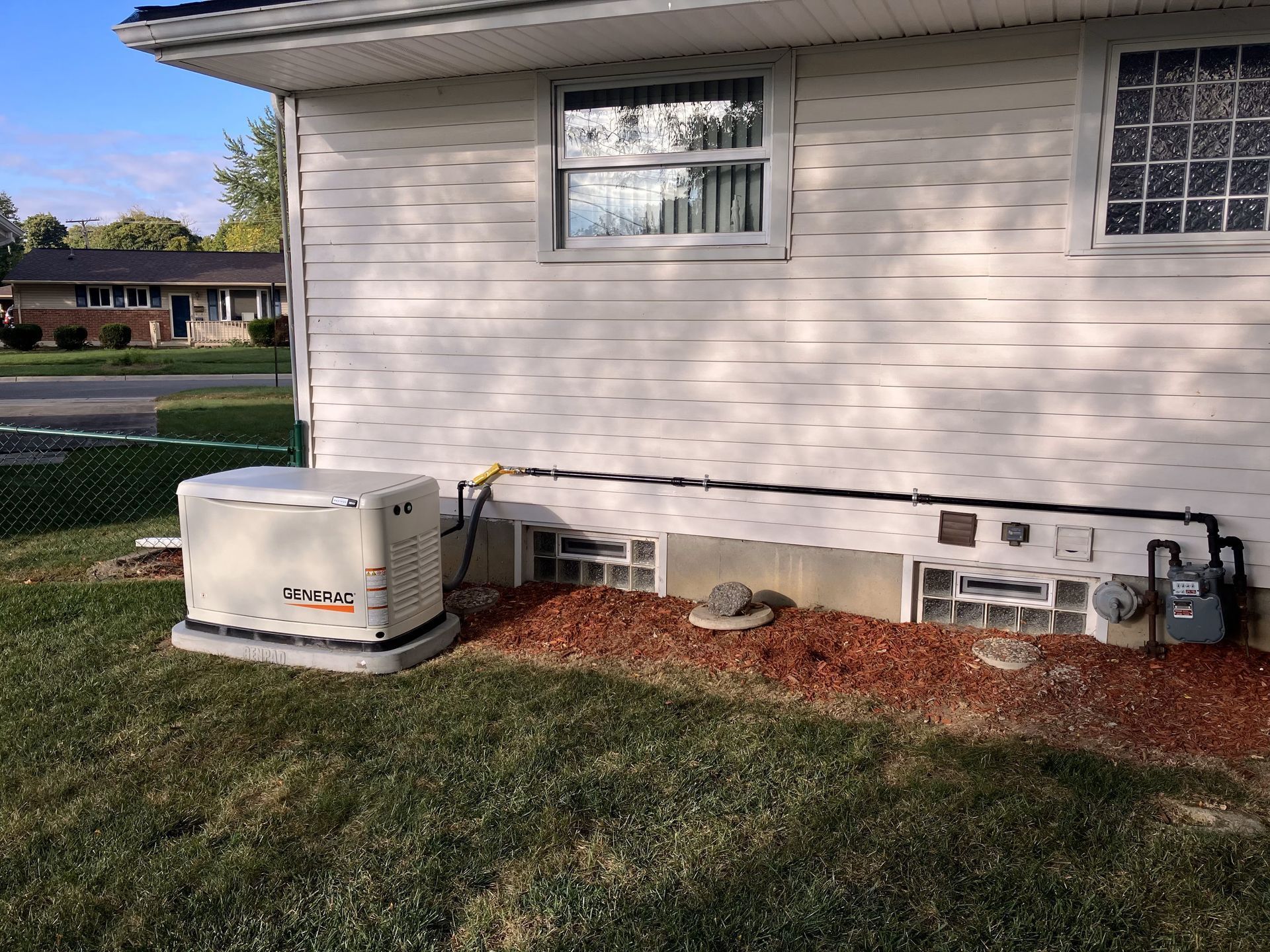 A white house with a generator on the side of it.