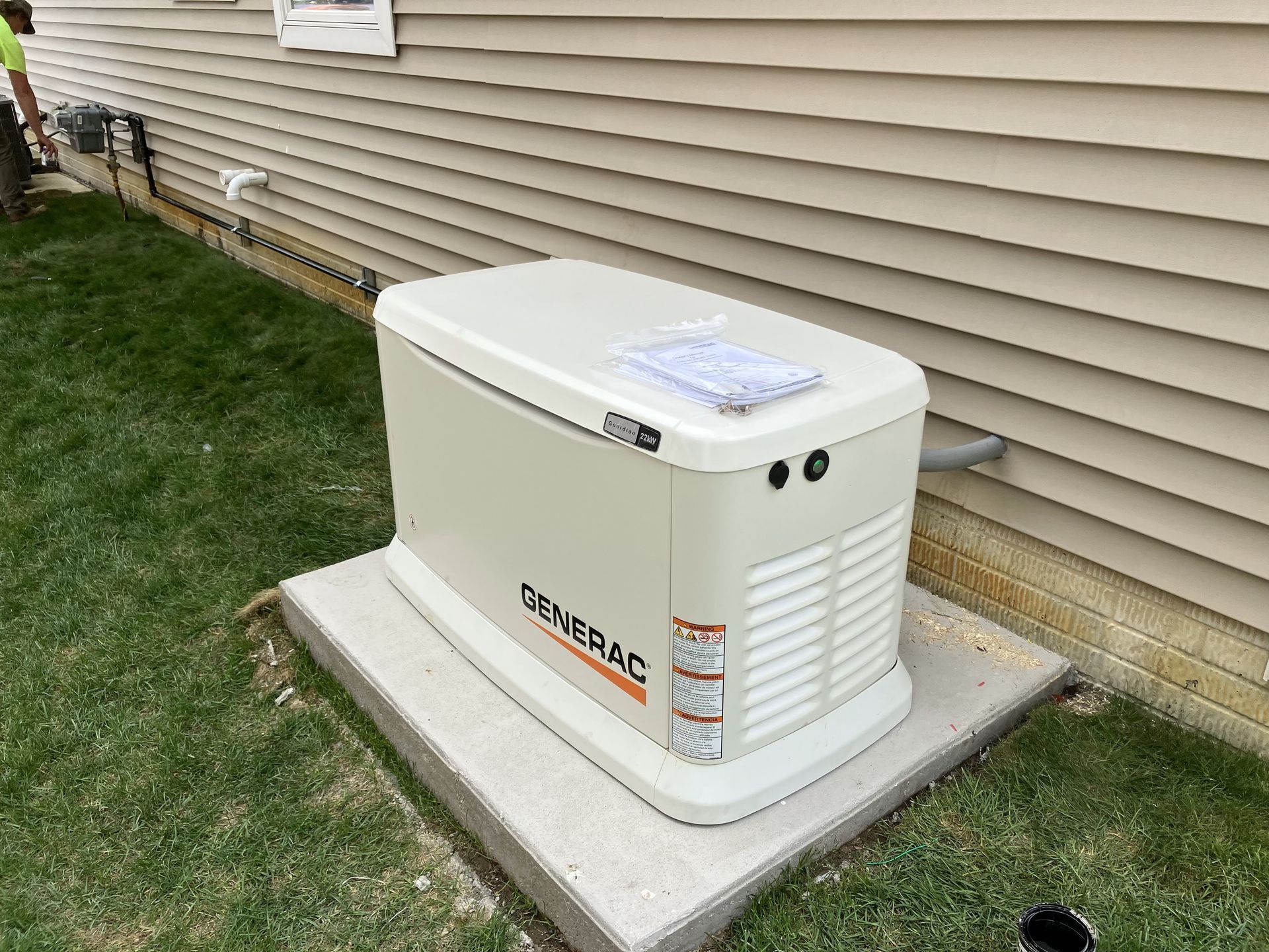 A generator is sitting on the side of a house.