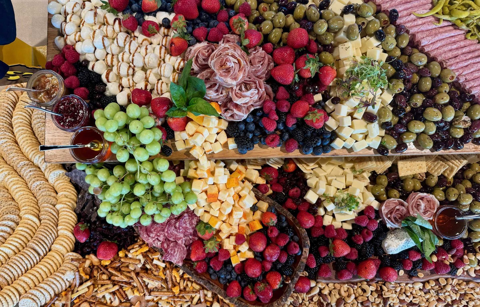 Charcuterie board: Various cheeses, fruits, olives, crackers, and meats arranged on a wooden serving board.