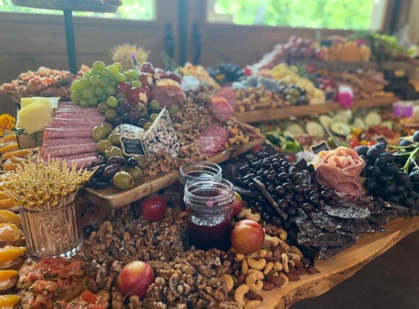 Charcuterie board: variety of cheeses, meats, fruits, nuts, and crackers arranged on wooden serving platters.