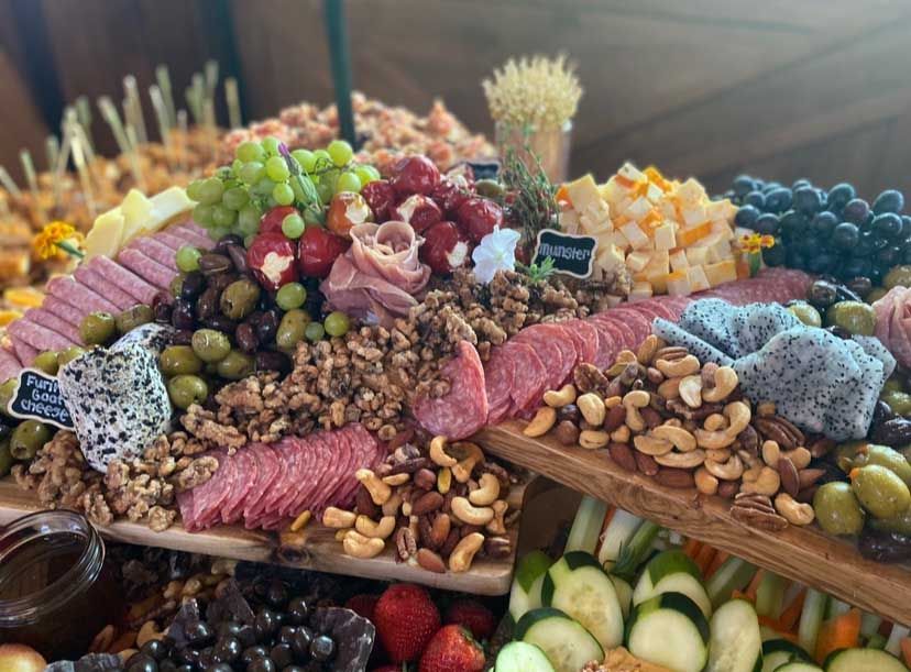 Charcuterie board with salami, nuts, grapes, cheese, and dragon fruit.