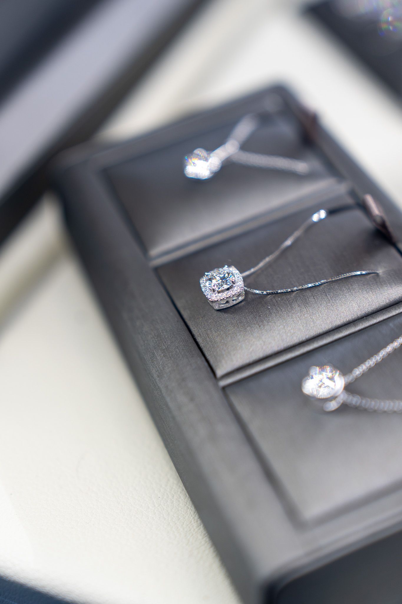 Three silver rings displayed on a black jewelry tray in a blurred close-up.
