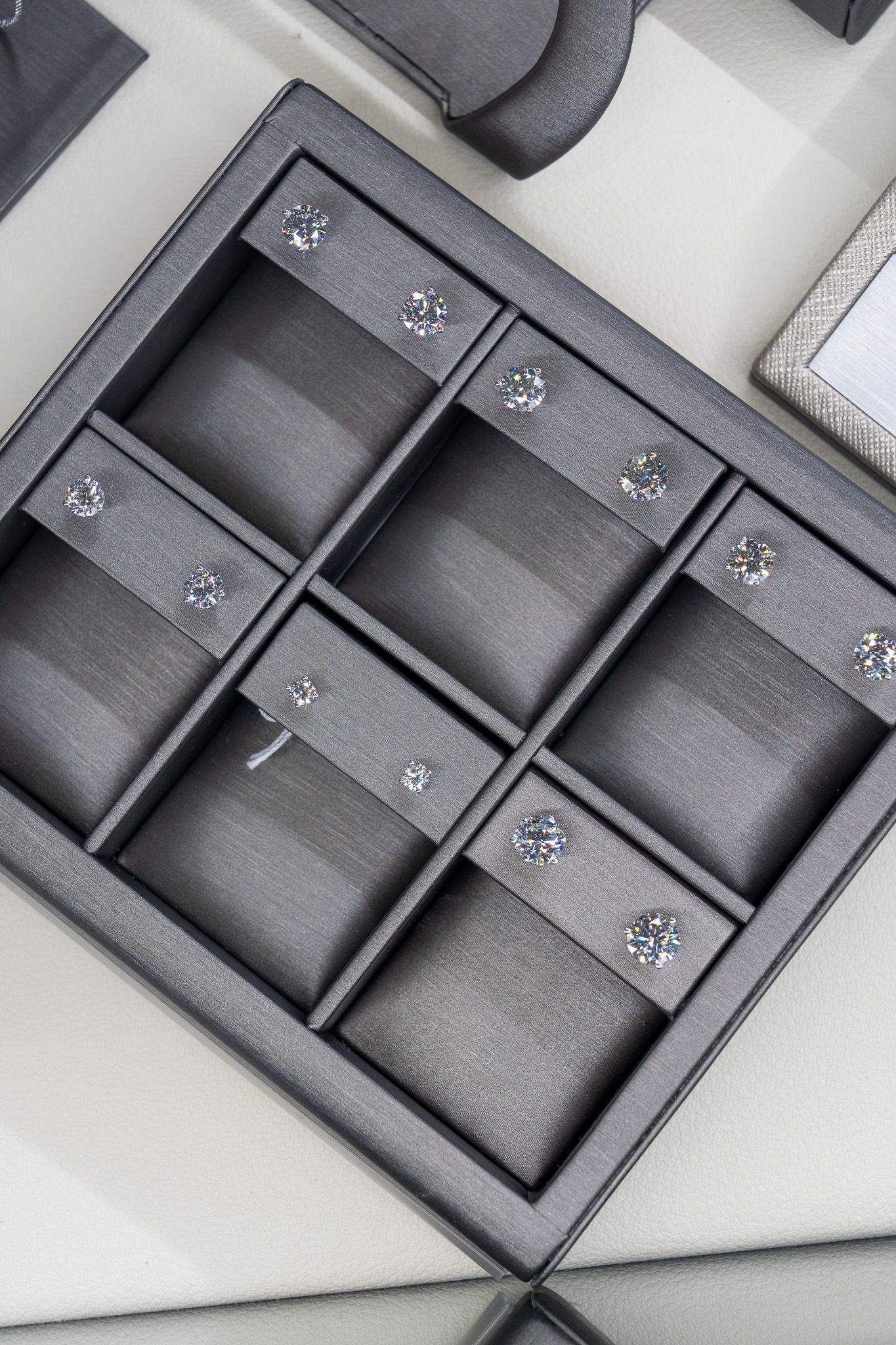 Open gray organizer tray with eight square compartments on a white surface.