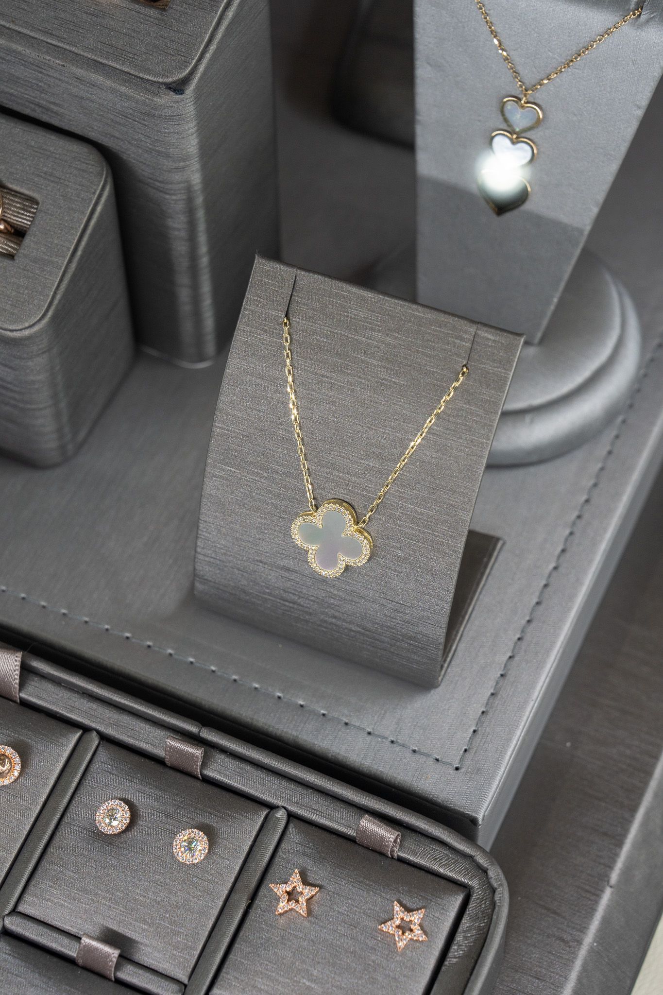 Jewelry display with gold necklaces and earrings on black velvet stands.