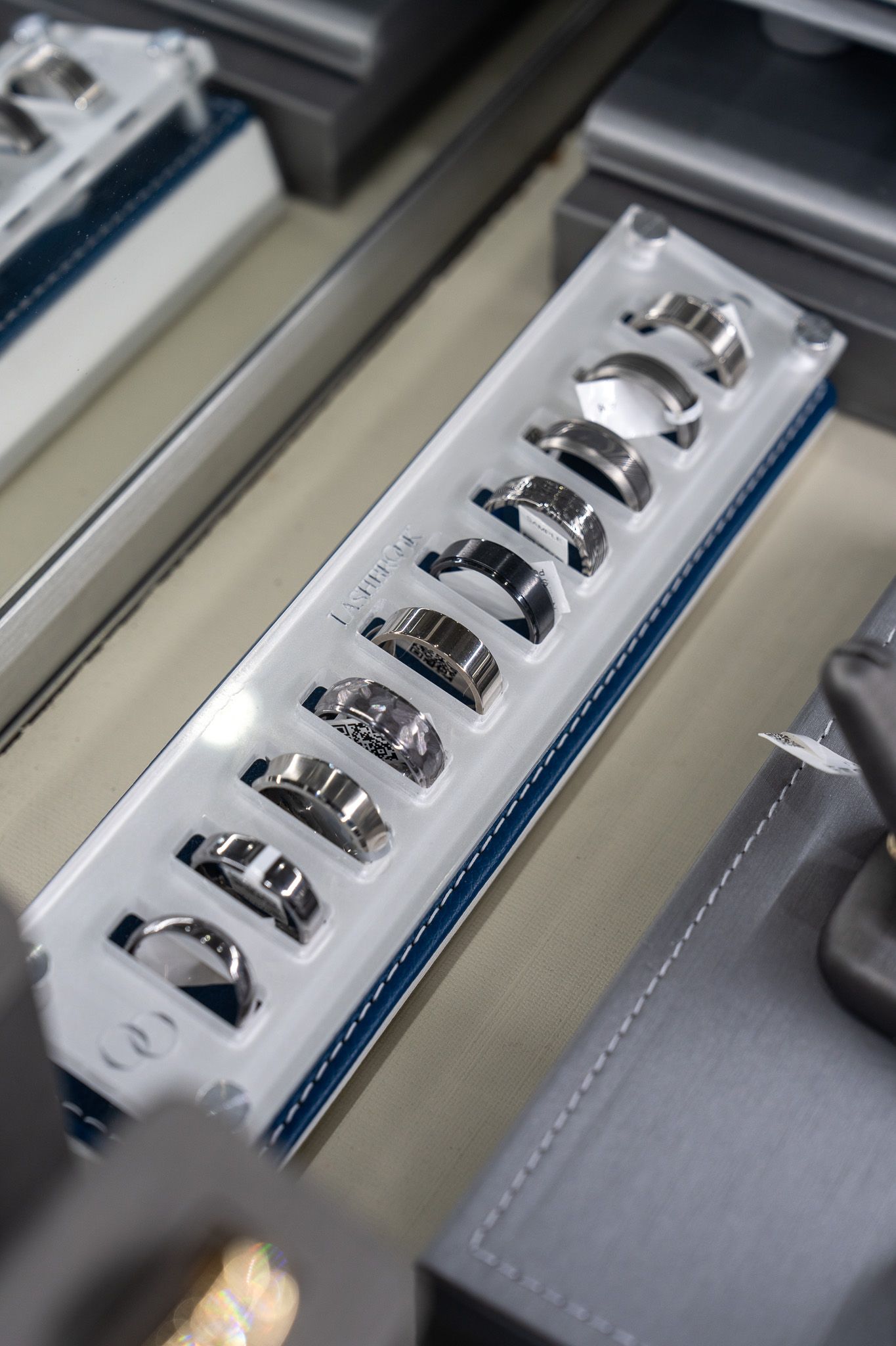 Close-up of a chrome tray holding several metal rings inside a machine or display case.