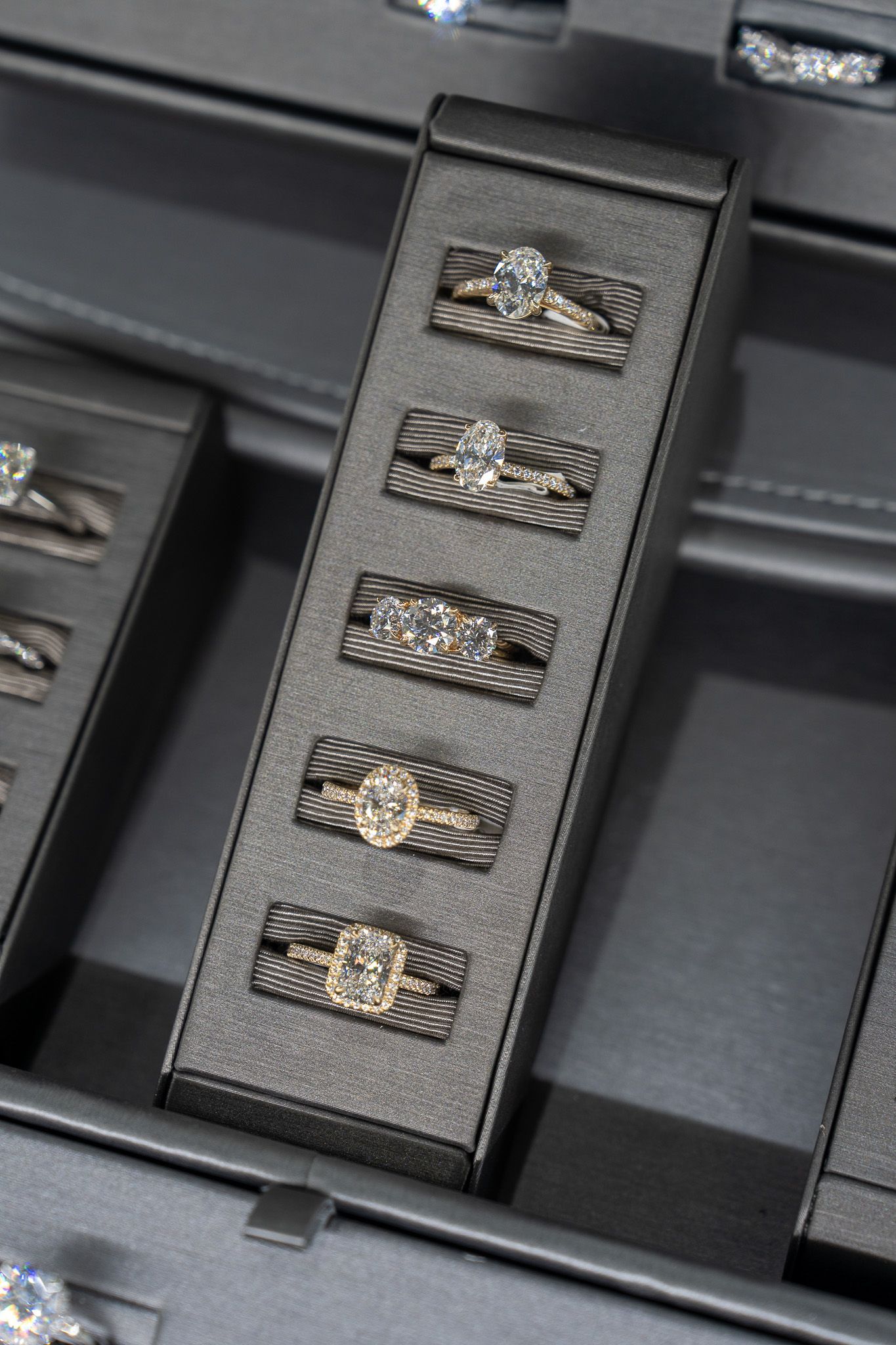 Black leather watch strap with five silver-toned links in a display box.