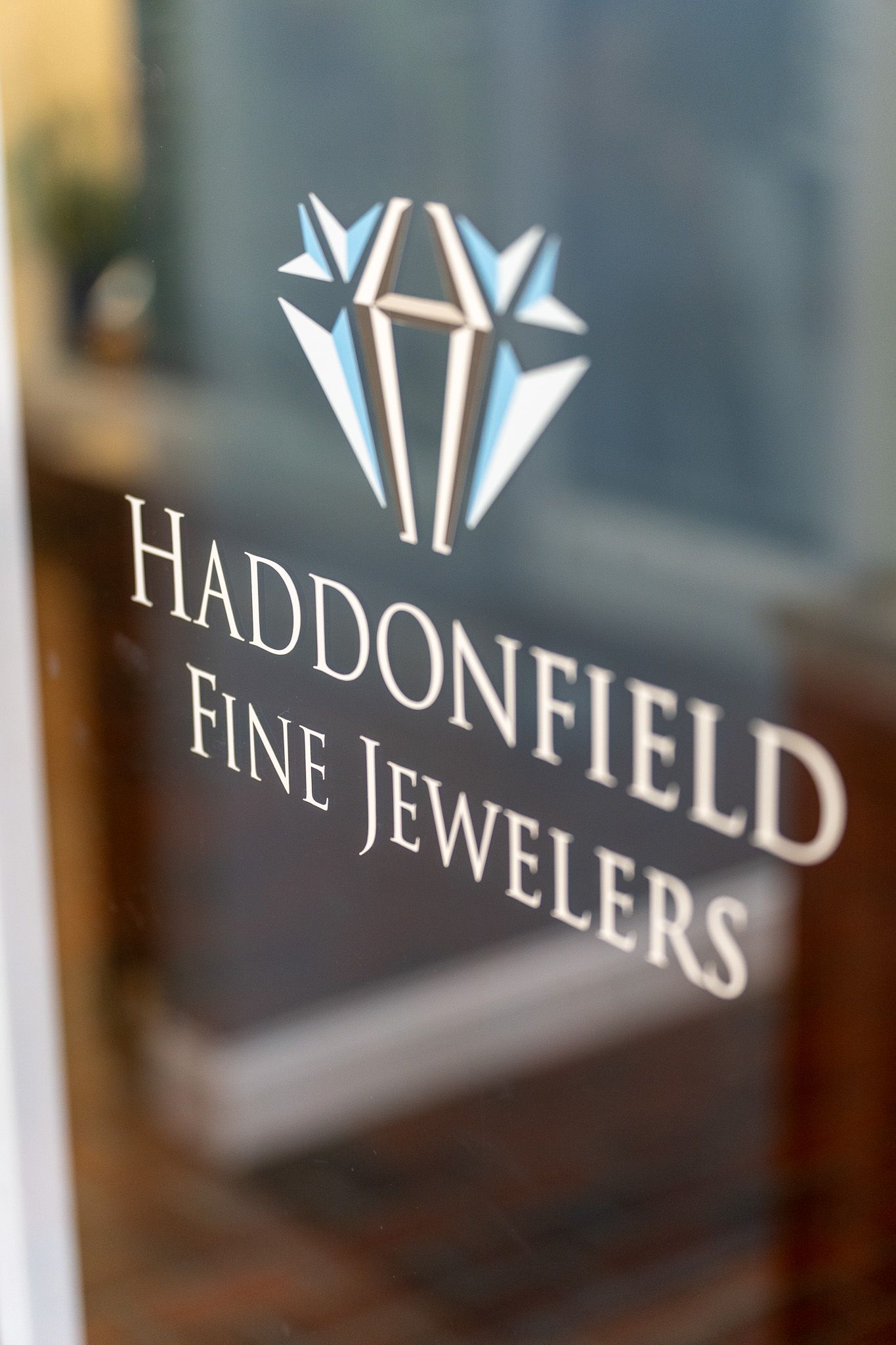 Haddonfield Fine Jewelers logo on a glass door, with a white geometric gem icon.