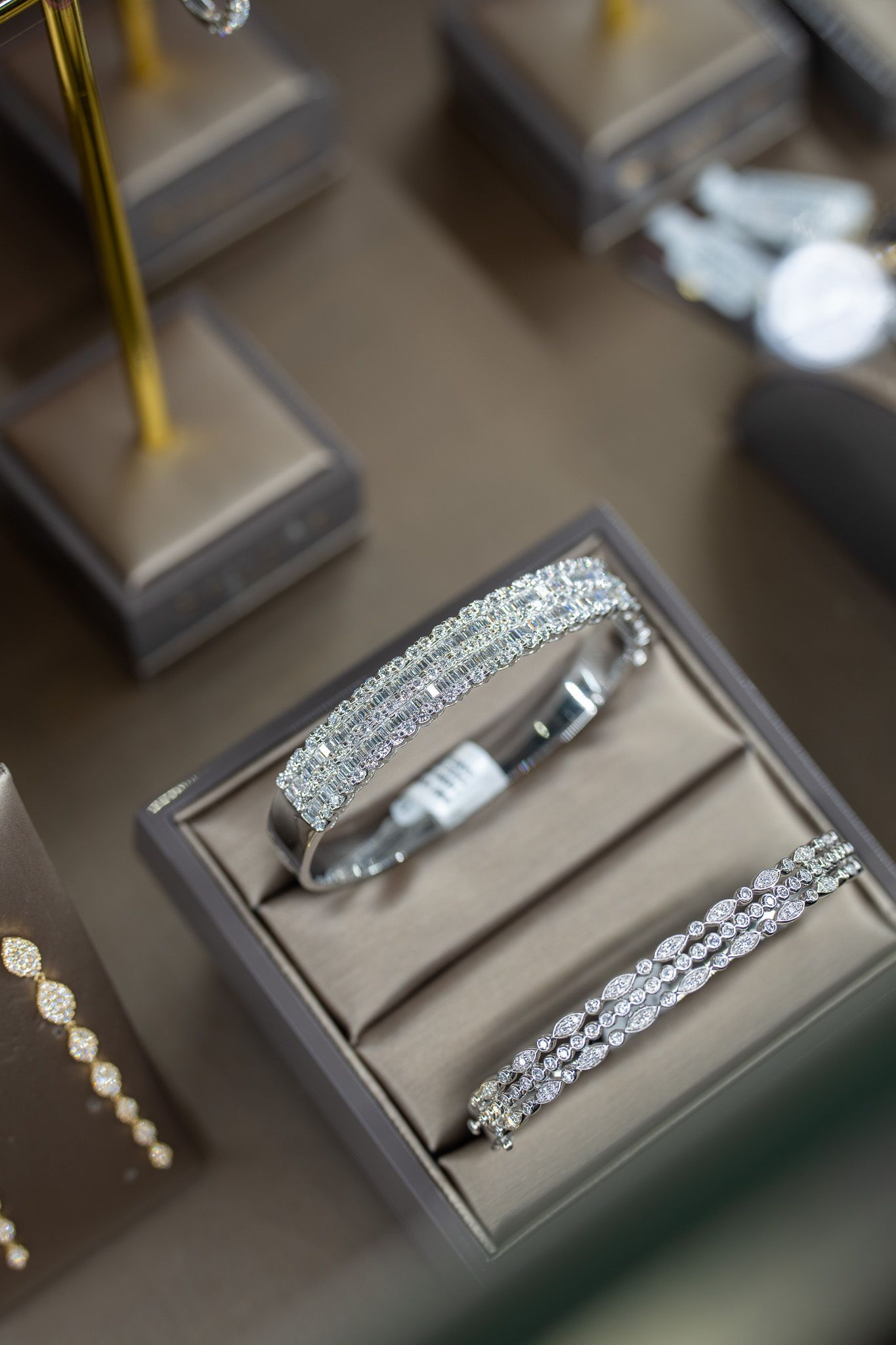 Silver bracelet on a beige display tray in a jewelry store showcase