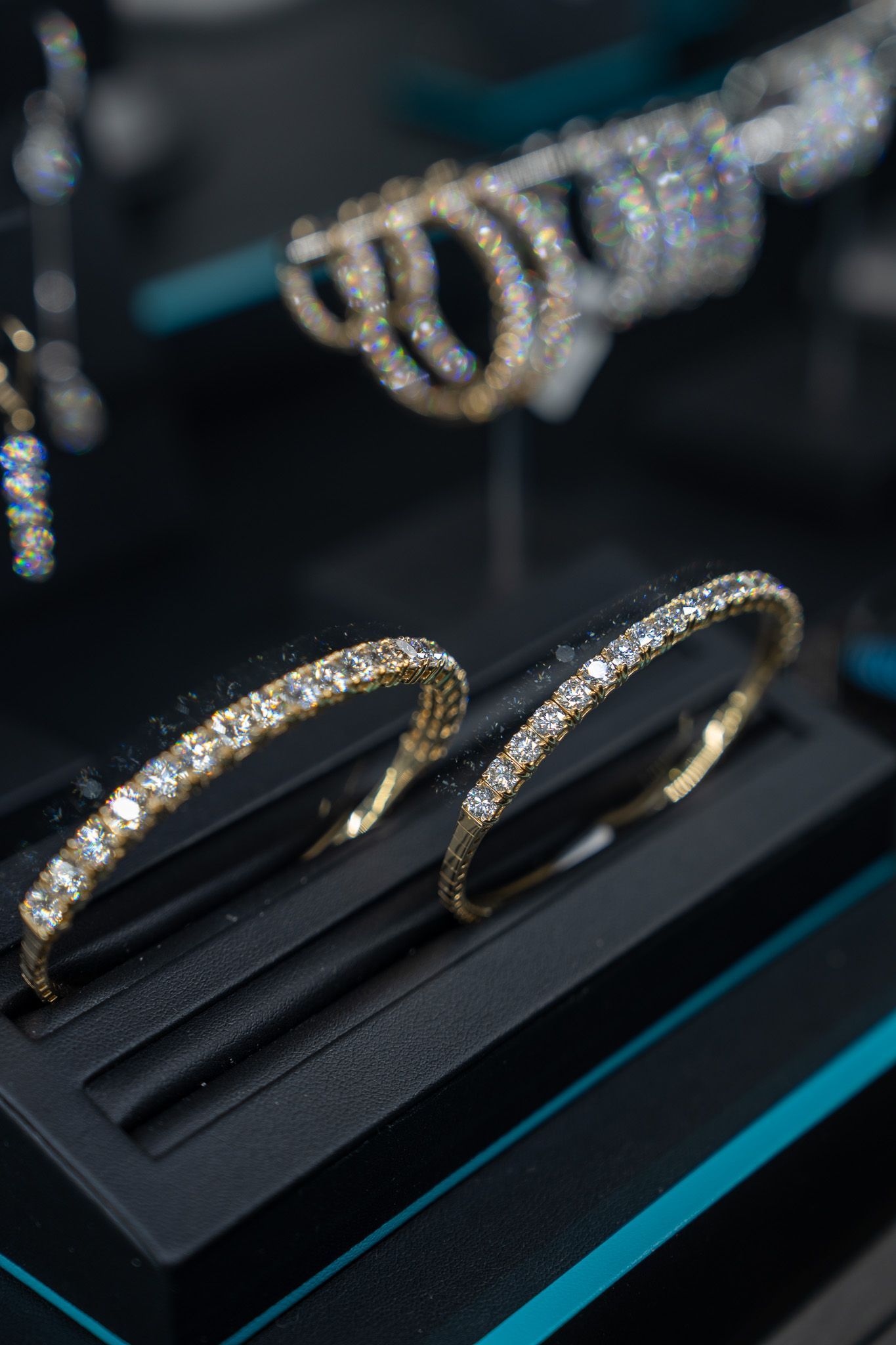 Diamond bracelets displayed on a black jewelry stand in a store case