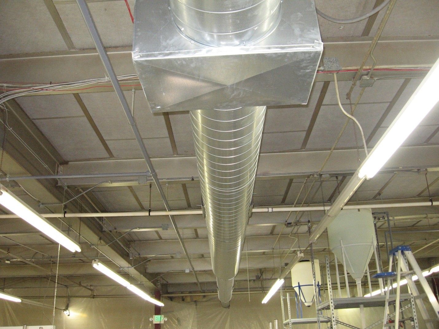 A large metal pipe is hanging from the ceiling of a building.