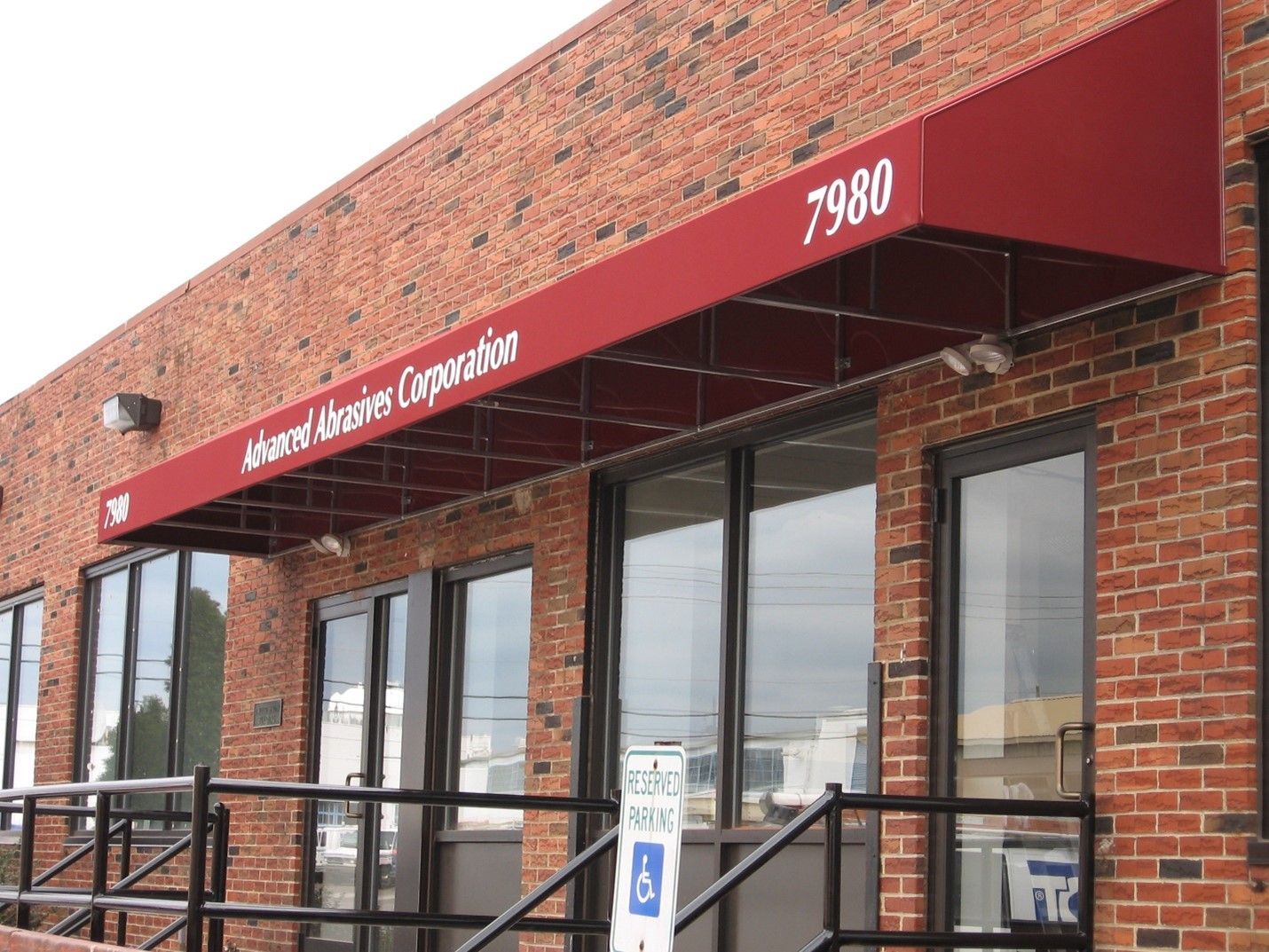 A red awning on a brick building with the number 7980 on it