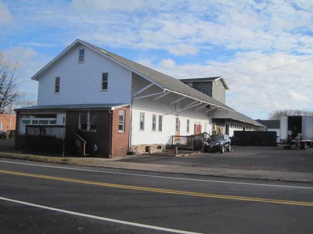A large white building sits on the side of a road