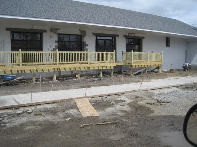 A white building with a wooden deck in front of it