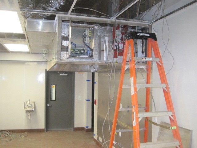 An orange ladder is in a room with a door