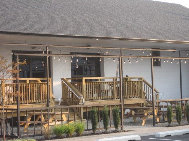 A white building with a wooden deck and stairs