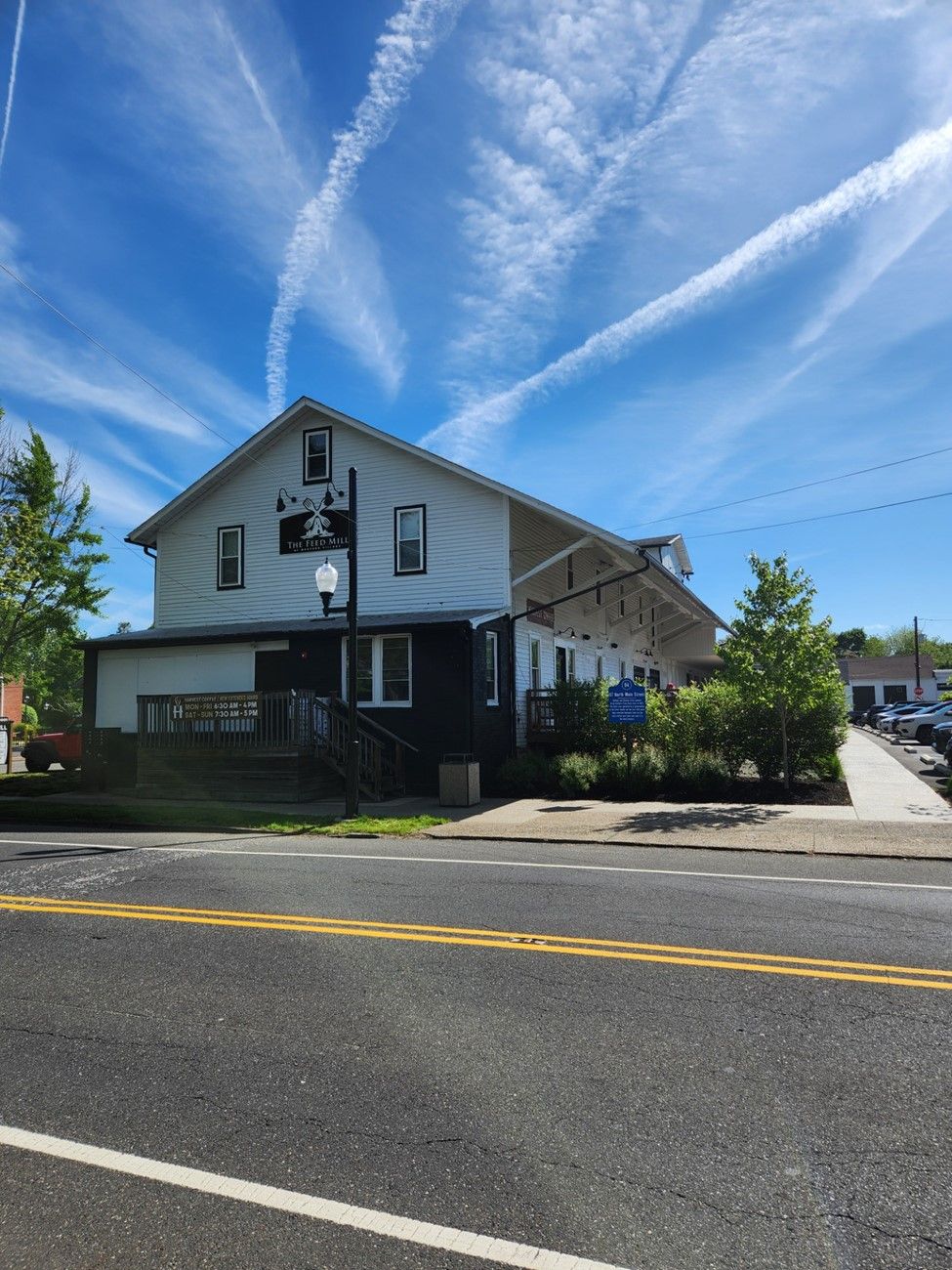 A large white building is sitting on the side of a road.