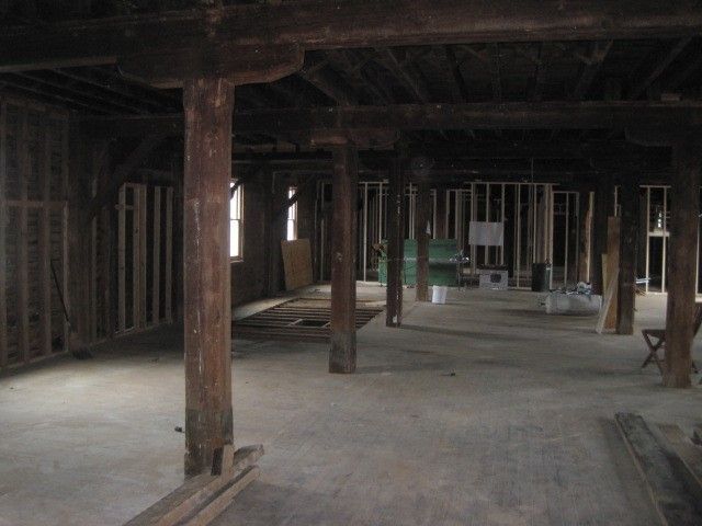 An empty room with wooden beams and a window.