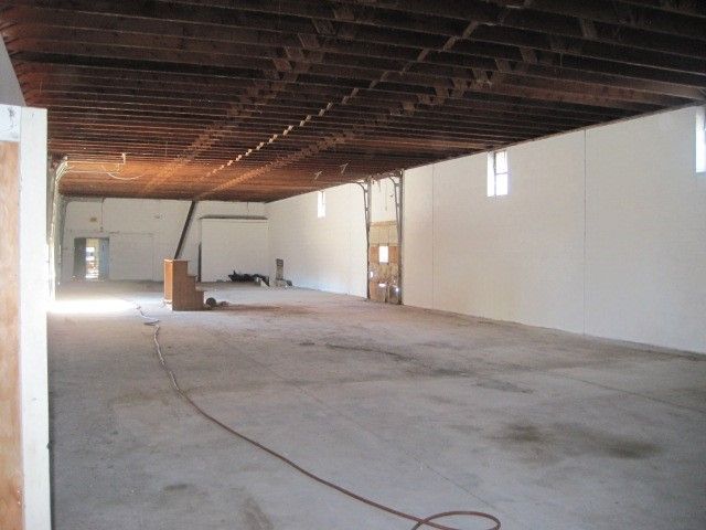 A large empty room with white walls and wooden beams
