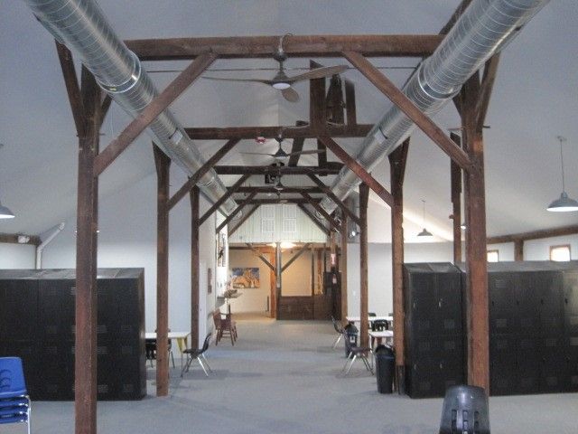 A long hallway with wooden beams and a ceiling fan