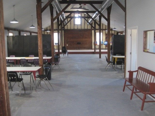 A long hallway with tables and chairs and a bench