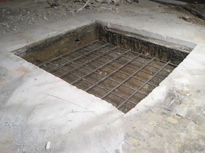 A hole in the ground with a metal frame in it.