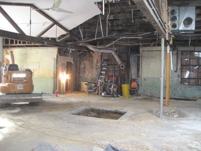 A case excavator is in the middle of a building under construction