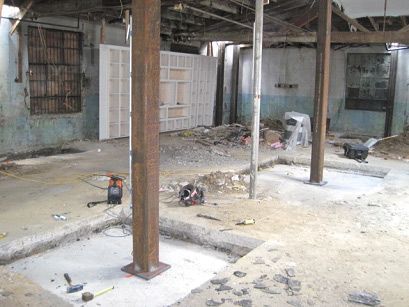 A building under construction with a lot of tools on the ground.