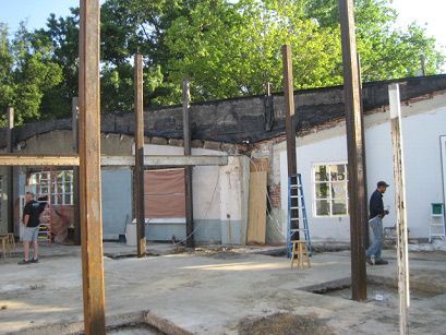 A man is standing in front of a building under construction