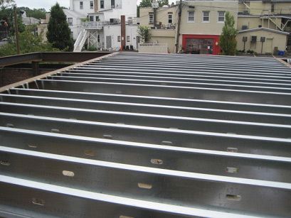 A roof that is being built with a building in the background