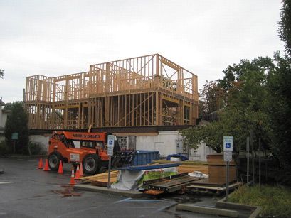 A large building is being built in a parking lot.