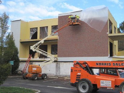A sale truck is parked in front of a building under construction