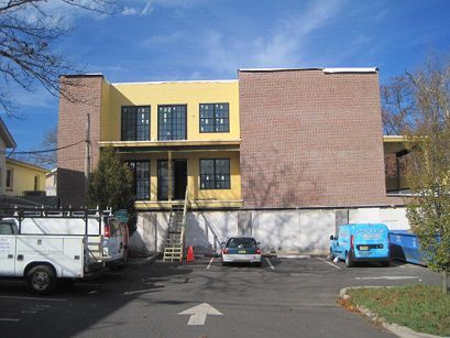 A building under construction with trucks parked in front of it